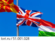 Flags of the United Kingdom, Macedonia and Hungary waving in the wind against the blue sky. Стоковое фото, фотограф Nobilior / Фотобанк Лори