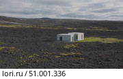 Stark white architectural design contrasting volcanic black terrain, nestled among rugged Icelandic mountain peaks beneath overcast skies. Стоковое AI-видео, аниматор Данил Руденко / Фотобанк Лори
