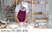 Senior man works in bakery as baker, kneads dough, works with flour. Стоковое видео, видеограф Яков Филимонов / Фотобанк Лори