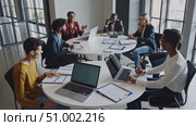 Colleagues collaborating, sharing ideas on laptops during team meeting in contemporary workspace, highlighting professional interaction and workplace communication. Стоковое AI-видео, аниматор Данил Руденко / Фотобанк Лори