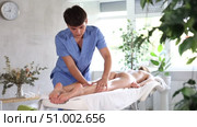 Young man actively rubs leg of young woman during general massage procedure. Стоковое видео, видеограф Яков Филимонов / Фотобанк Лори