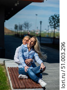 Two surprisingly similar women are sitting on a bench in an embrace and smiling. A middle-aged woman and her elderly mother. Beautiful well-groomed mother and daughter family look. Стоковое фото, фотограф Михаил Решетников / Фотобанк Лори