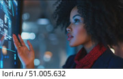 Woman interacts with digital interface in modern workspace at night. Стоковое AI-видео, аниматор Сергей Толмачёв / Фотобанк Лори