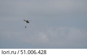Firefighting helicopter flying with bambi bucket. Стоковое видео, видеограф Данил Руденко / Фотобанк Лори