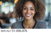 A cheerful woman with curly hair enjoys her time in a lively café, radiating positivity and connection with her surroundings. Стоковое AI-видео, аниматор Данила Большаков / Фотобанк Лори