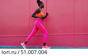 A runner strides confidently in bright athletic attire, creating an energetic atmosphere alongside a vibrant wall in the city. Стоковое AI-видео, аниматор Данила Большаков / Фотобанк Лори