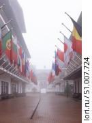 SOCHI, RUSSIA - MAY 03, 2024: Olympic village with a view of buildings and national flags of different countries on a foggy spring day. Редакционное фото, фотограф Наталья Угрюмова / Фотобанк Лори