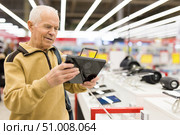 senor man pensioner buying modern tablet digital in showroom of digital electronic goods store. Стоковое фото, фотограф Татьяна Яцевич / Фотобанк Лори