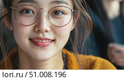 A young woman with glasses exhibits a cheerful expression, dressed in a cozy sweater, enjoying her time in a bustling cafe atmosphere. Стоковое AI-видео, аниматор Данила Большаков / Фотобанк Лори