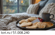 Indulge in heart-shaped pancakes served alongside fresh strawberries and coffee on a cozy bed tray in a warm, inviting bedroom. Стоковое AI-видео, аниматор Данила Большаков / Фотобанк Лори