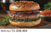A gourmet burger features juicy beef patty, fresh herbs, and caviar, served elegantly in a fine dining atmosphere, showcasing culinary artistry. Стоковое AI-видео, аниматор Данила Большаков / Фотобанк Лори