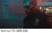Police officer in dramatic lighting reflects on duty while surrounded by smoke in urban environment. Стоковое AI-видео, аниматор Сергей Толмачёв / Фотобанк Лори