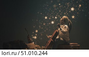 Musician plays cello amidst glowing stars in a mystical setting during a serene evening performance. Стоковое AI-видео, аниматор Сергей Толмачёв / Фотобанк Лори