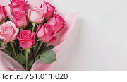 Spectacular bouquet of pink flowers in transparent wrapping paper on white background. Nine large roses in close-up. Banner or postcard with copy space for text. Zoom, approximation. Стоковое AI-видео, аниматор Ирина / Фотобанк Лори