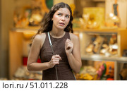 Beautiful young girl customer choosing something in souvenir shop during tourist trip in Spain. Стоковое фото, фотограф Яков Филимонов / Фотобанк Лори