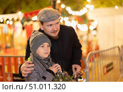 Man with son stands in middle of shopping area decorated for New Year holidays. Стоковое фото, фотограф Яков Филимонов / Фотобанк Лори