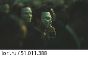 Gathering of masked individuals in suits at a mysterious event in a dimly lit setting. Стоковое AI-видео, аниматор Сергей Толмачёв / Фотобанк Лори