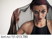 A grinning woman in a black veil with dark makeup and an earring in her nose. Halloween Dead Bride Costume. Portrait of the sinister Witch in front of the coven. Стоковое фото, фотограф Михаил Решетников / Фотобанк Лори