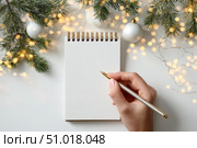 Woman's hand writing in empty notebook at the desk with Christmas decoration. Back to life, goal list. Plan, goals, checklist, idea concept. Top view, copy space. New Year. Blank White Paper Sheet. Стоковое AI-изображение, AI-художник Марина Демидюк / Фотобанк Лори