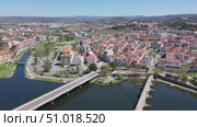 Picturesque aerial view of residential districts of Mirandela city with brownish tiled roofs and two bridges crossing Tua river on spring day, Braganca, Portugal. Стоковое видео, видеограф Яков Филимонов / Фотобанк Лори