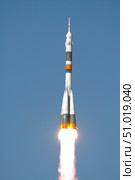 The Soyuz TMA-12 spacecraft lifts off into a cloudless sky. Стоковое фото, фотограф Stocktrek Images, Inc. / ТАСС / Фотобанк Лори