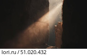 Light beams through stone crevices in ancient ruins at sunrise creating a mystical atmosphere. Стоковое AI-видео, аниматор Сергей Толмачёв / Фотобанк Лори