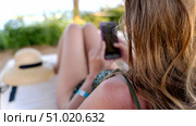Woman with smartphone on sun lounger by the sea. Стоковое фото, фотограф Igor Skripachev / Фотобанк Лори