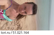 A 50-year-old European woman in a swimsuit walks along the beach in Doha, Qatar. Стоковое видео, видеограф IRYNA ZAKHARANKA / Фотобанк Лори