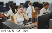 Female student rubs her tired eyes with her hands after working for long time at computer monitor in a classroom. Стоковое видео, видеограф Яков Филимонов / Фотобанк Лори