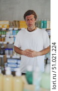 Man in summer clothes is standing in a pharmacy and holding his stomach, he feels cramps and indigestion. Buyer came to a European pharmacy for pills for diarrhea. Стоковое видео, видеограф Яков Филимонов / Фотобанк Лори
