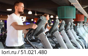 Young man working out on elliptical machine. Стоковое видео, видеограф Яков Филимонов / Фотобанк Лори