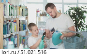 Dad and son scan barcode on packaging of laundry conditioner. Стоковое видео, видеограф Яков Филимонов / Фотобанк Лори