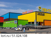 Magnitogorsk, Russian Federation - August 05, 2025: "Tetris" Colorful shopping center with vibrant storefronts and busy street traffic, showcasing urban lifestyle and commercial activity in a lively city environment. Редакционное фото, фотограф Ирина Ручушкина / Фотобанк Лори