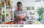 African man make choice choose consider canned beans in store. Стоковое видео, видеограф Яков Филимонов / Фотобанк Лори