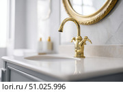 Modern golden faucet and marble stone sink. Stylish white sink, faucets in a light interior. Copper brass tap. Domestic Appliances. Clean bright bathroom. Household equipment. New Contemporary style. Стоковое AI-изображение, AI-художник Марина Демидюк / Фотобанк Лори