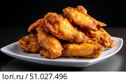 Delicious crispy fried chicken wings piled on white plate. Стоковое AI-изображение, AI-художник Юрий Поздников / Фотобанк Лори