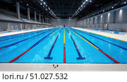 Empty olympic swimming pool with lane markers awaiting swimmers. Стоковое AI-изображение, AI-художник Юрий Поздников / Фотобанк Лори