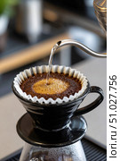 Barista pouring hot water into coffee dripper with paper filter. Стоковое AI-изображение, AI-художник Юрий Поздников / Фотобанк Лори