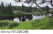 A suspension bridge over a river in the countryside in summer. Стоковое видео, видеограф Виктор Тихонов / Фотобанк Лори