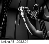 BDSM concept. A woman in a leather corset holds a black lash with a long fringe. Role-playing games for adults. Close-up of sex toys for domination. The whip in female hands. Стоковое фото, фотограф Михаил Решетников / Фотобанк Лори
