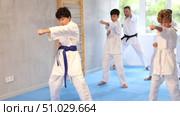 Group of children posing together, practicing karate moves at class indoor in gym. Стоковое видео, видеограф Яков Филимонов / Фотобанк Лори