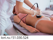 procedure removing cellulite on female abdomen, cavitation belly massage. Ultrasonic massage for weight loss. Correction of a female figure without surgical intervention. Close-up of the tummy. Стоковое фото, фотограф Михаил Решетников / Фотобанк Лори