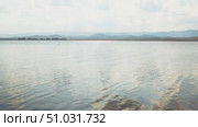 Bashkortostan, Russian Federation - August 07, 2025: Aerial view of tranquil lake reflecting clouds and mountains, showcasing serene landscape with lush greenery and open sky. Редакционное видео, видеограф Ирина Ручушкина / Фотобанк Лори