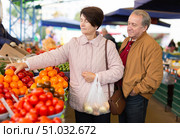 elderly man and woman buy vegetables at an open market. Стоковое фото, фотограф Татьяна Яцевич / Фотобанк Лори