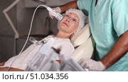 Experienced male cosmetologist performing female face skin massage procedure in cosmetology clinic. Стоковое видео, видеограф Яков Филимонов / Фотобанк Лори