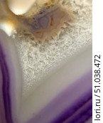 Macro shot of amethyst cross-section with characteristic purple and white stripes, crystal structure and mineralized center. The image conveys the natural texture of the stone and the play of colors, ideal for use in design, scientific illustrations and decorative projects. Стоковое фото, фотограф Анна Кривицкая / Фотобанк Лори