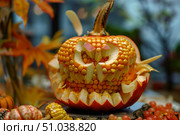Halloween pumpkin carving decorated with corn kernels displaying a spooky face. Стоковое AI-изображение, AI-художник Иван Рябоконь / Фотобанк Лори