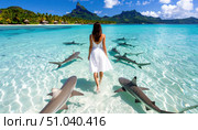 A woman in a white dress walks fearlessly among reef sharks in crystal-clear tropical waters, symbolizing courage, freedom, and a daring connection with nature. Стоковое AI-изображение, AI-художник Ольга Сухарева / Фотобанк Лори