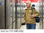 elderly man choosing refrigerator in showroom of electrical appliance store. Стоковое фото, фотограф Татьяна Яцевич / Фотобанк Лори