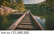 Wooden dock extends over tranquil lake near a dense forest. Scene captures the rustic beauty of nature with the calm waters and lush trees. Стоковое видео, видеограф Данила Большаков / Фотобанк Лори